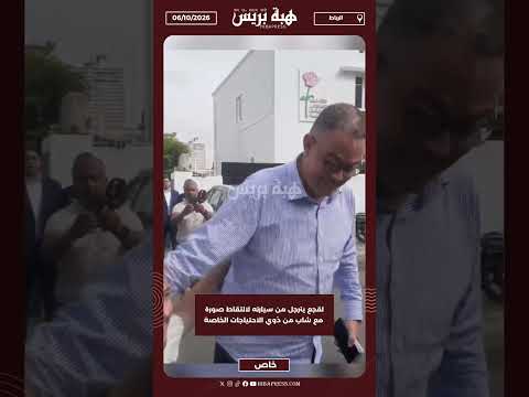 لقجع يترجل من سيارته لالتقاط صورة مع شاب من ذوي الاحتياجات الخاصة